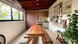 Vista interna de uma sala de jantar com piso de madeira e grandes janelas em Lajeado.