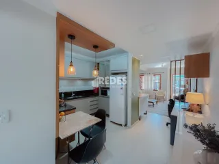 Sala de estar com cozinha integrada em ambiente claro.