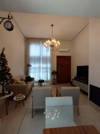 Sala de estar iluminada com sofá e lustre de cristal.