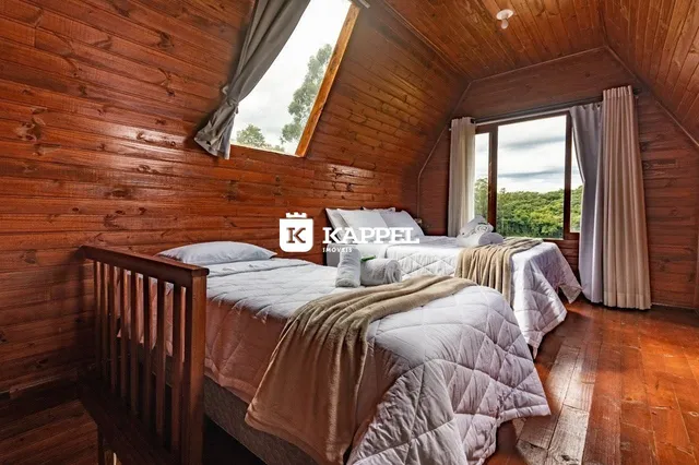 Um quarto com paredes de madeira e uma cama com lençóis brancos.