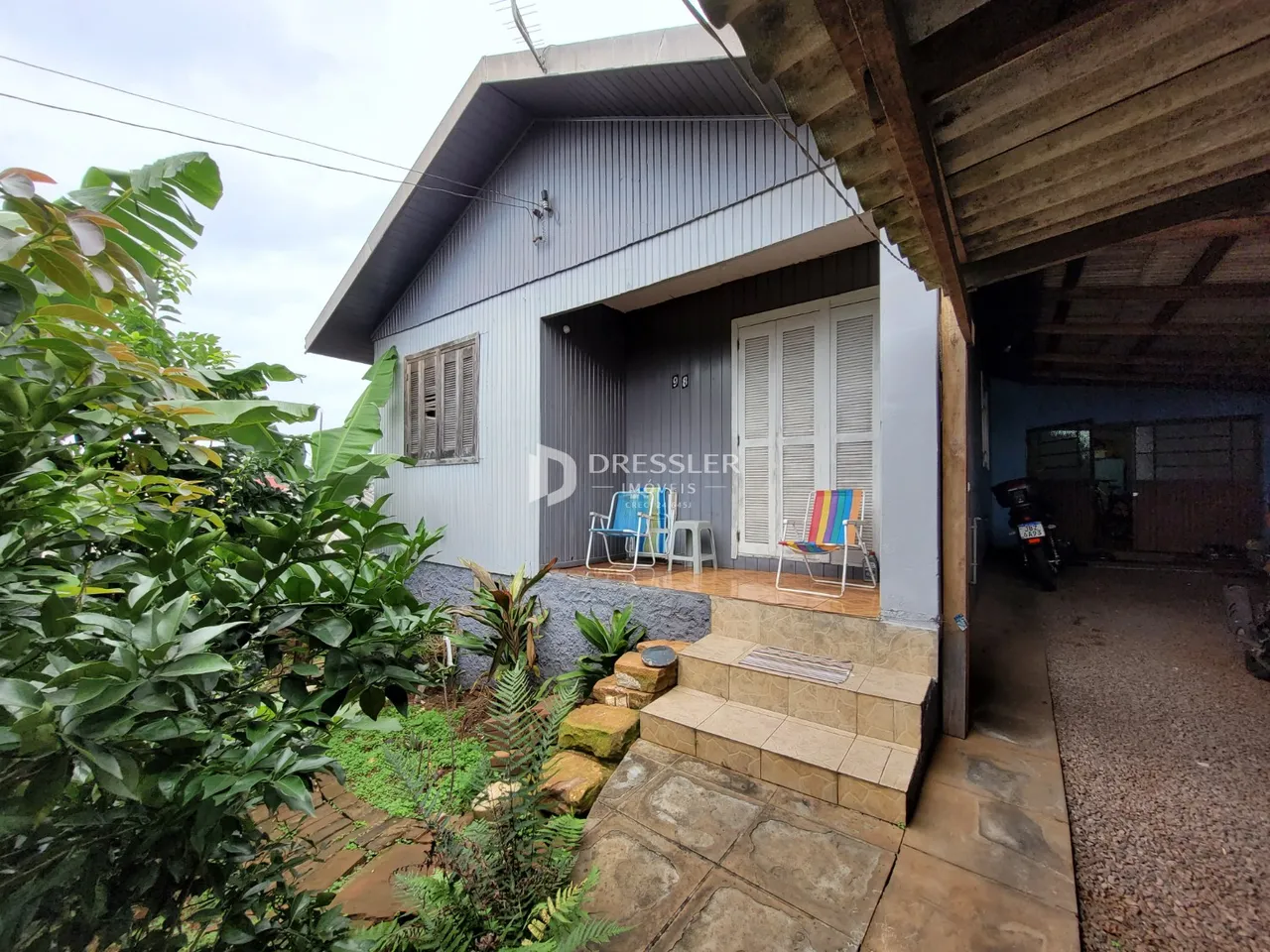 Fachada de uma casa em Lajeado, Brasil, com jardim frontal e área coberta.
