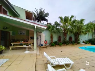 Foto da área externa com piscina e vegetação.