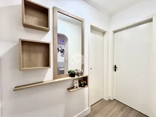 Foto de um corredor interno com paredes brancas e prateleiras de madeira.