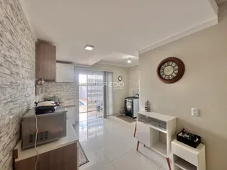 Ambiente de cozinha e sala de estar com piso de cerâmica claro.