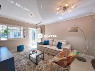 Foto da sala de estar com sofá e luminária moderna.