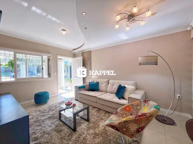 Foto da sala de estar com sofá e luminária moderna.