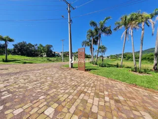 Vista da fachada de uma propriedade em Lajeado, Brasil, com paisagismo e palmeiras.