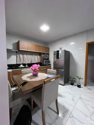 Foto de uma sala de jantar com mesa de madeira e armários em um apartamento.