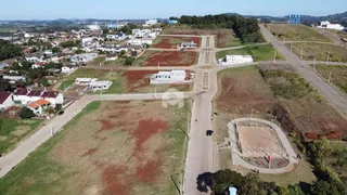 Vista aérea de uma área de terreno com algumas construções residenciais e espaços abertos.