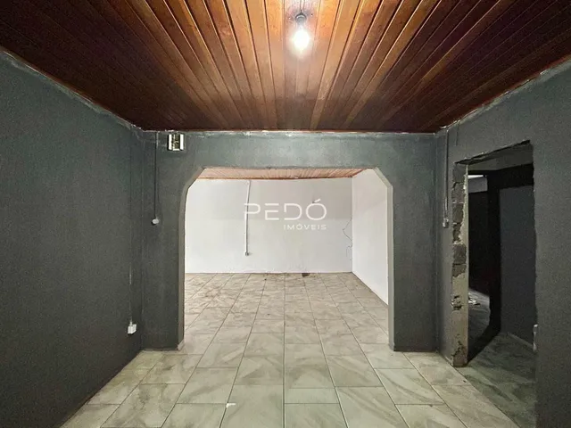 Hall de entrada com piso de cerâmica e teto de madeira em um imóvel.