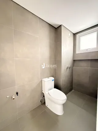 Foto de um banheiro com revestimento cerâmico e piso claro.