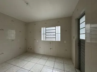 Foto de um cômodo interno com paredes brancas e piso de cerâmica.
