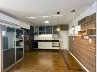 Ambiente moderno com piso de madeira e cozinha integrada em Lajeado, Brasil.