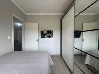 Quarto com cama e paredes brancas.