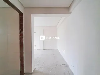 Corredor interno com paredes brancas e piso cru em um imóvel.