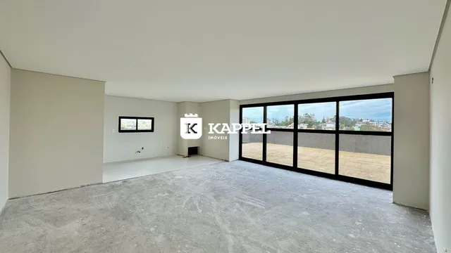 Uma foto de um espaço interno amplo e vazio com paredes brancas e piso de concreto.