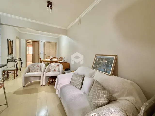 Sala de estar com sofá branco e piso claro em um imóvel.
