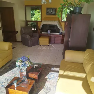 Sala de estar com sofá amarelo e lareira em ambiente residencial.