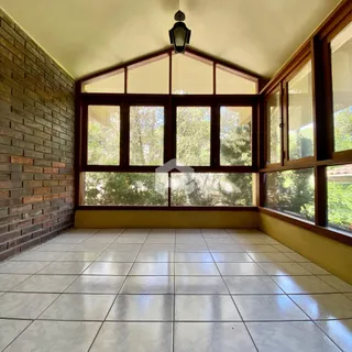 Uma sala com piso de cerâmica e parede de tijolos expostos.