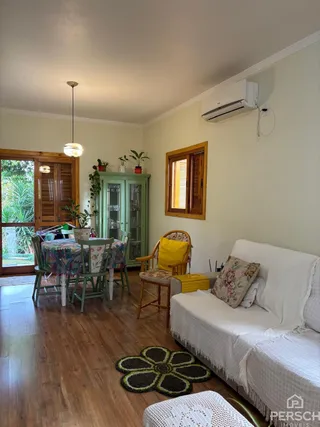 Uma sala de estar com piso de madeira e um sofá branco.