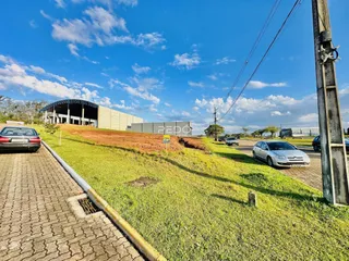 Vista externa de um terreno gramado com um grande edifício ao fundo.