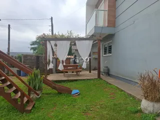 Vista externa de uma residência com jardim e estrutura de madeira em Lajeado.