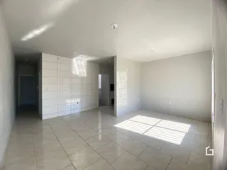 Corredor interno de uma residência com piso de cerâmica clara e paredes brancas.