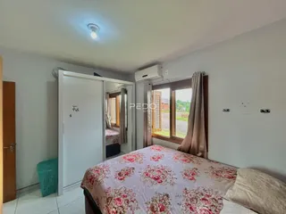 Quarto com cama e janela em ambiente interno.