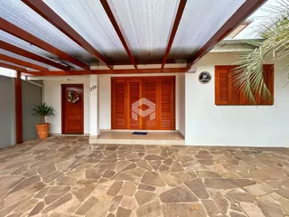 Fachada de uma residência com piso de pedra e porta de madeira.