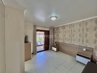 Ambiente interno de uma sala com piso de cerâmica clara e parede com papel de parede.