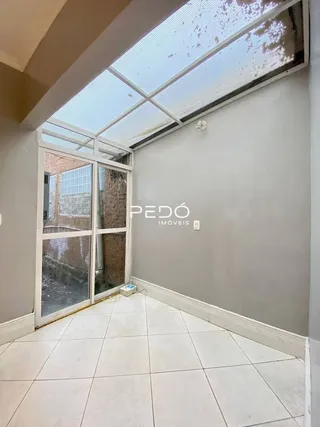 Interior com teto de claraboia e portas de vidro em uma residência.