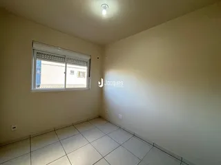 Quarto interno com piso de cerâmica e janela na sala.