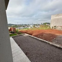 Foto de um terreno aberto com terra vermelha e caminho de acesso.
