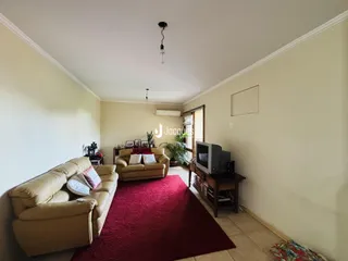 Foto de uma sala de estar com sofá e tapete vermelho.