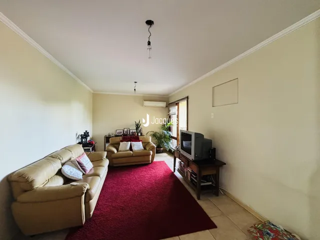 Foto de uma sala de estar com sofá e tapete vermelho.