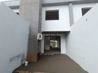 Vista externa de um pátio entre paredes brancas de um imóvel.