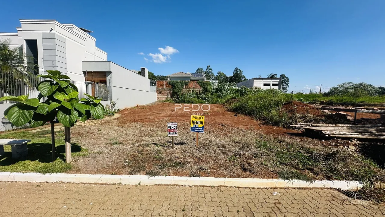 Vista externa de uma propriedade com terreno aberto e construção moderna.