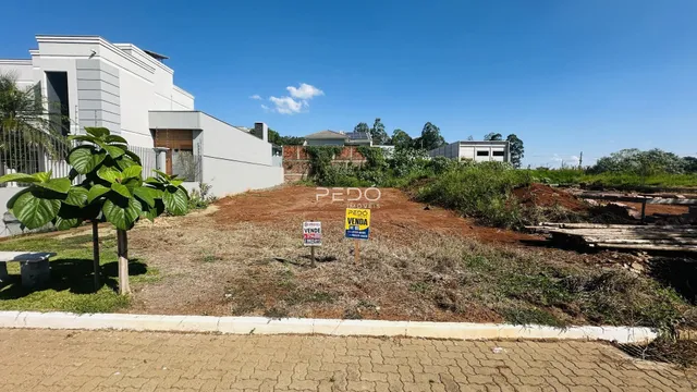 Vista externa de uma propriedade com terreno aberto e construção moderna.