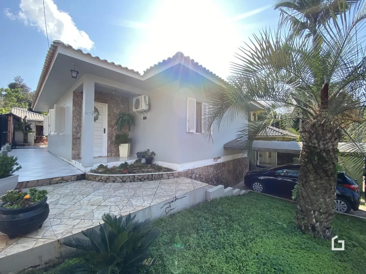 Fachada de uma residência em Lajeado, Brasil, com jardim e palmeira.
