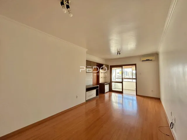 Sala de estar com piso de madeira e paredes brancas.
