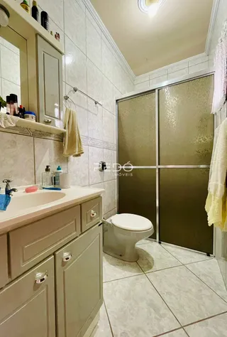 Foto de um banheiro com azulejos brancos e louças sanitárias.
