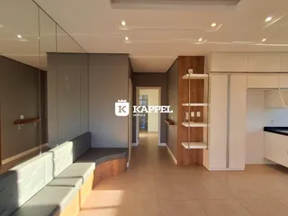 Sala de estar moderna com sofá e armários brancos em um ambiente claro.