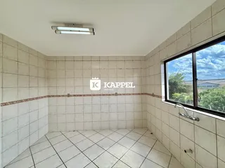 Foto interna de um cômodo com piso e paredes de azulejo claro.