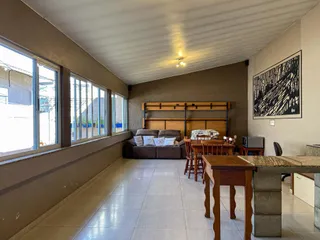 Uma sala de estar com janela e cama de madeira.