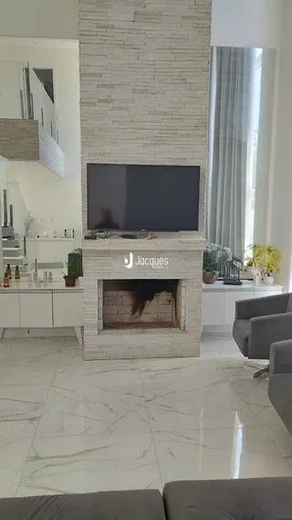 Sala de estar com lareira e piso de mármore claro.