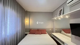 Foto de um quarto com cama e cortinas claras.