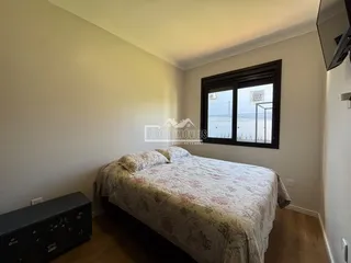 Quarto com cama e janela de grande porte em um imóvel.