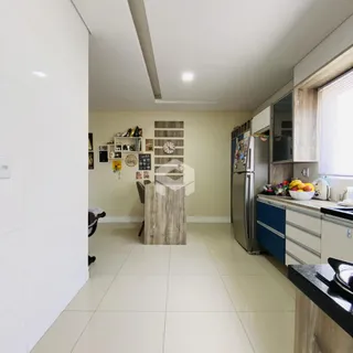 Ambiente interno de uma sala de estar com cozinha integrada em Lajeado.