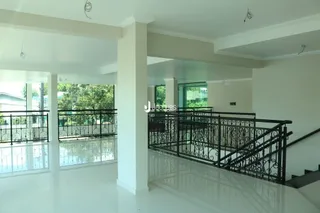 Vista de um espaço interno com paredes brancas e grades de ferro.