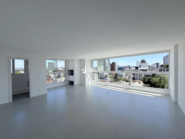 Sala de estar ampla com grande janela oferecendo vista panorâmica da cidade.